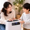 空気清浄機を操作する親子