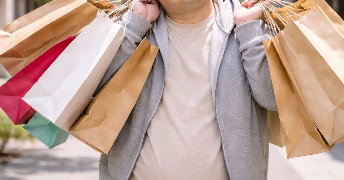 大量の紙袋を持ち歩く男性